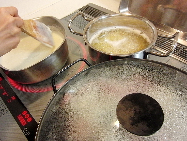 お湯の沸いた別鍋でマカロニを茹でながら、ホワイトソースを混ぜる様子